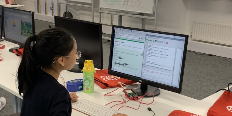 A young person writes Python code.
