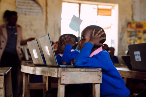 A child at a laptop in a classroom in rural Kenya.