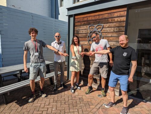 A group of people celebrating the returned Astro Pi computer.