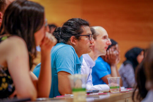 Educators and researchers listen to a talk at a conference.