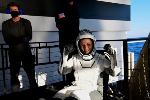 Samantha Cristoforetti in gives a thumbs up wearing a space suit.