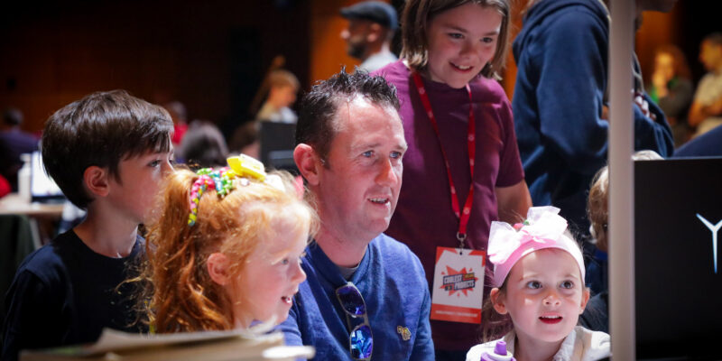 Young people and an adult mentor at a computer at Coolest Projects Ireland 2023.