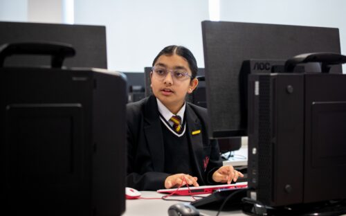 A secondary school age learner in a computing classroom.