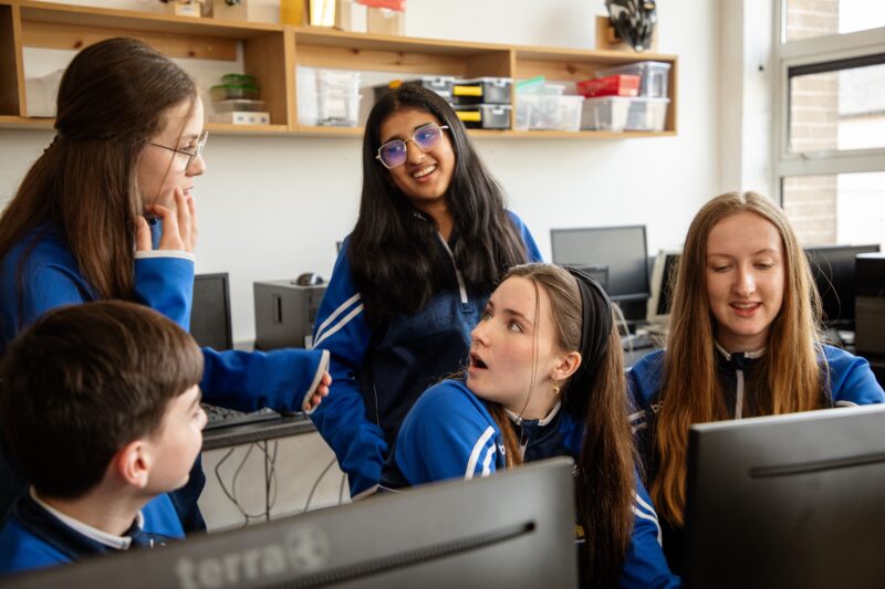 A group of students at a computer at secondary schools.
