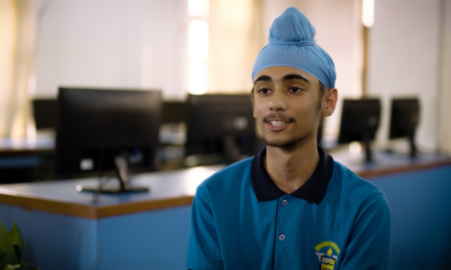 A young person sits in a classroom.