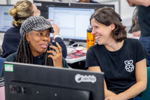 Two smiling adults at a computer. 