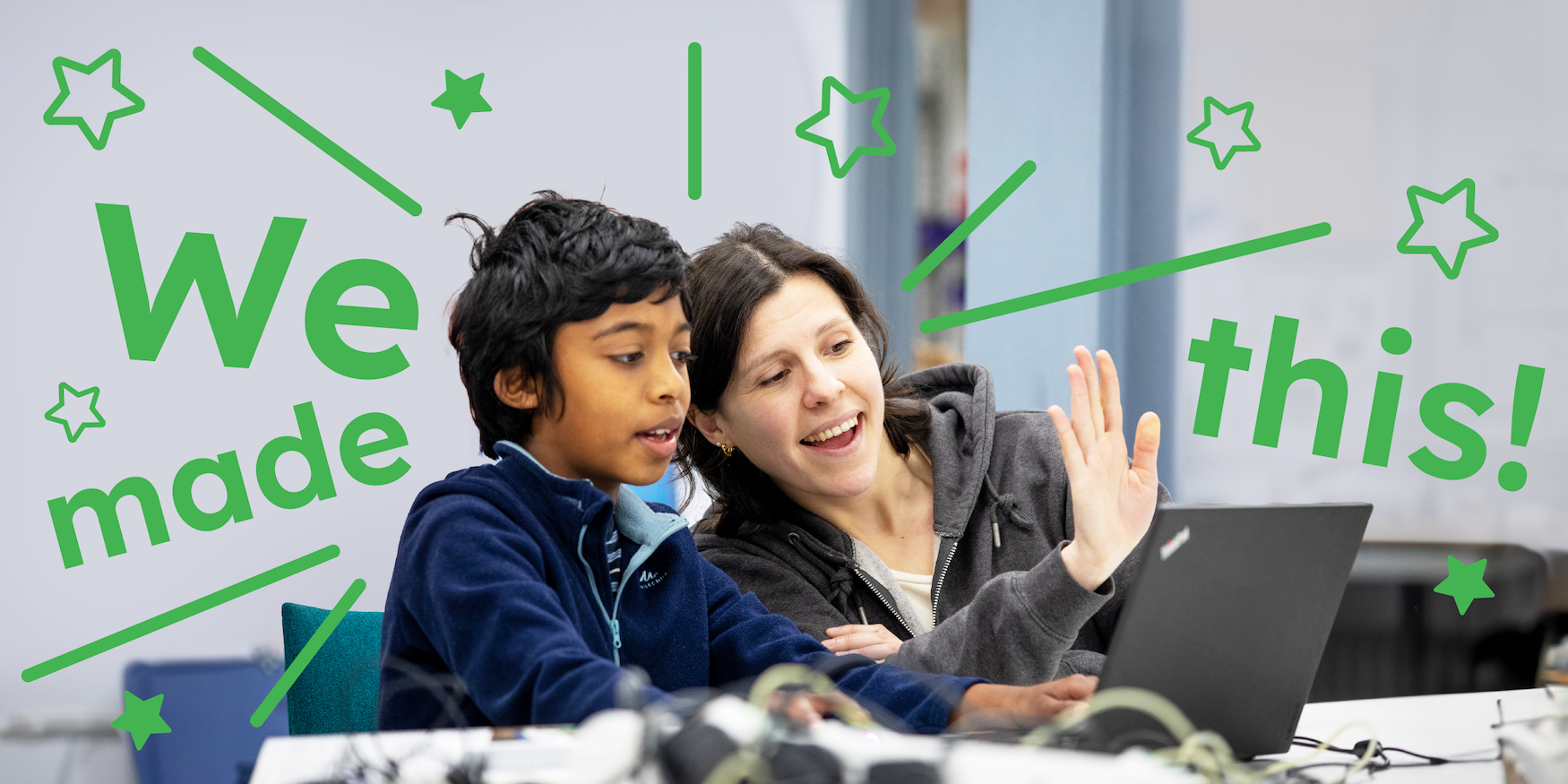A mentor and a young tech creator at a computer at a Code Club session.