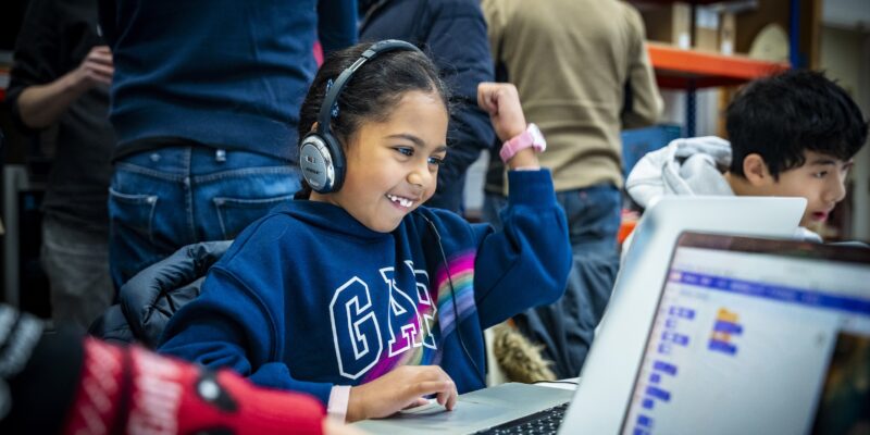 A young person celebrates at a Code Club.