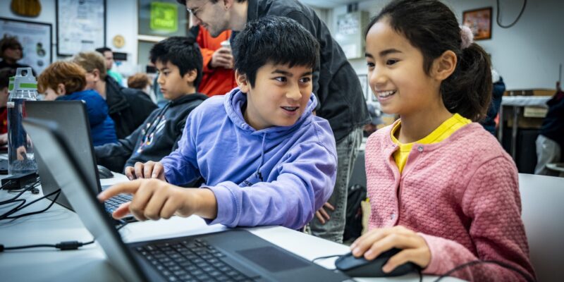 Two young people work together at a Code Club.