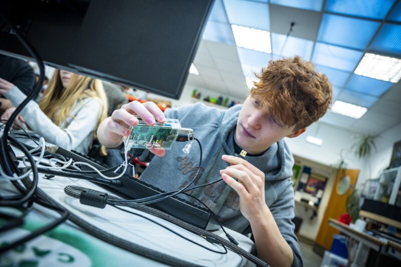 A young person connects a Raspberry Pi computer at a Code Club.