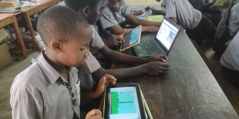 Young people using tablets in a classroom.