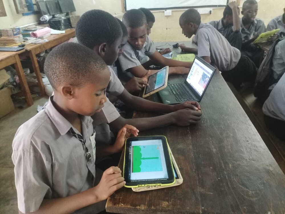 Young people using tablets in a classroom.