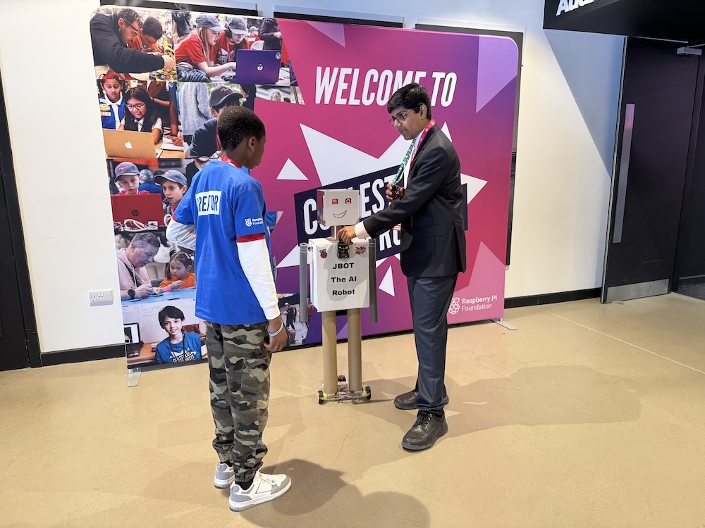 Jay showing his project, J Bot, to another young creator.