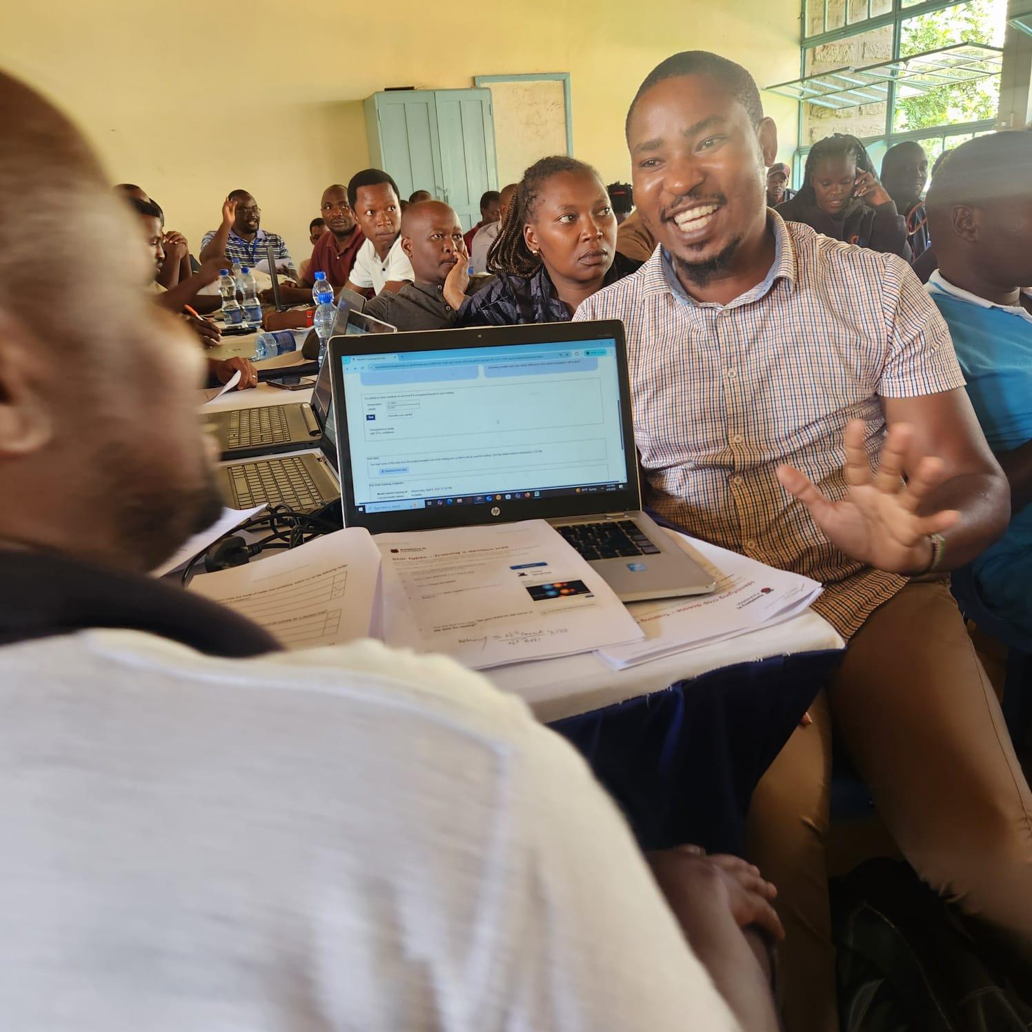 Students in a classroom setting; two of them are using a laptop to learn about AI.