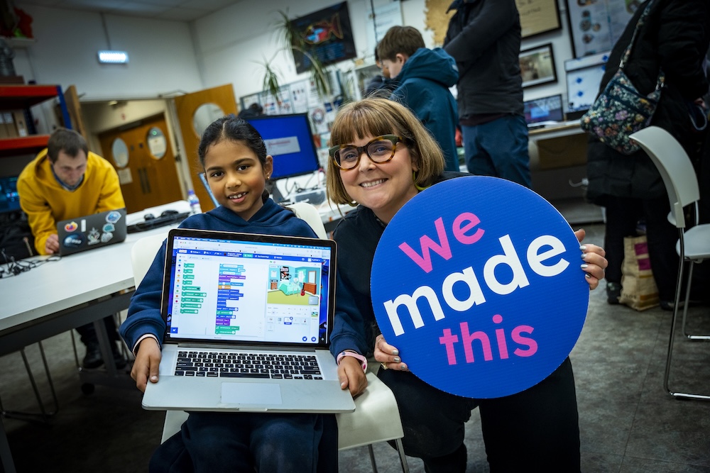 A mentor with a young coder in a Code Club session.