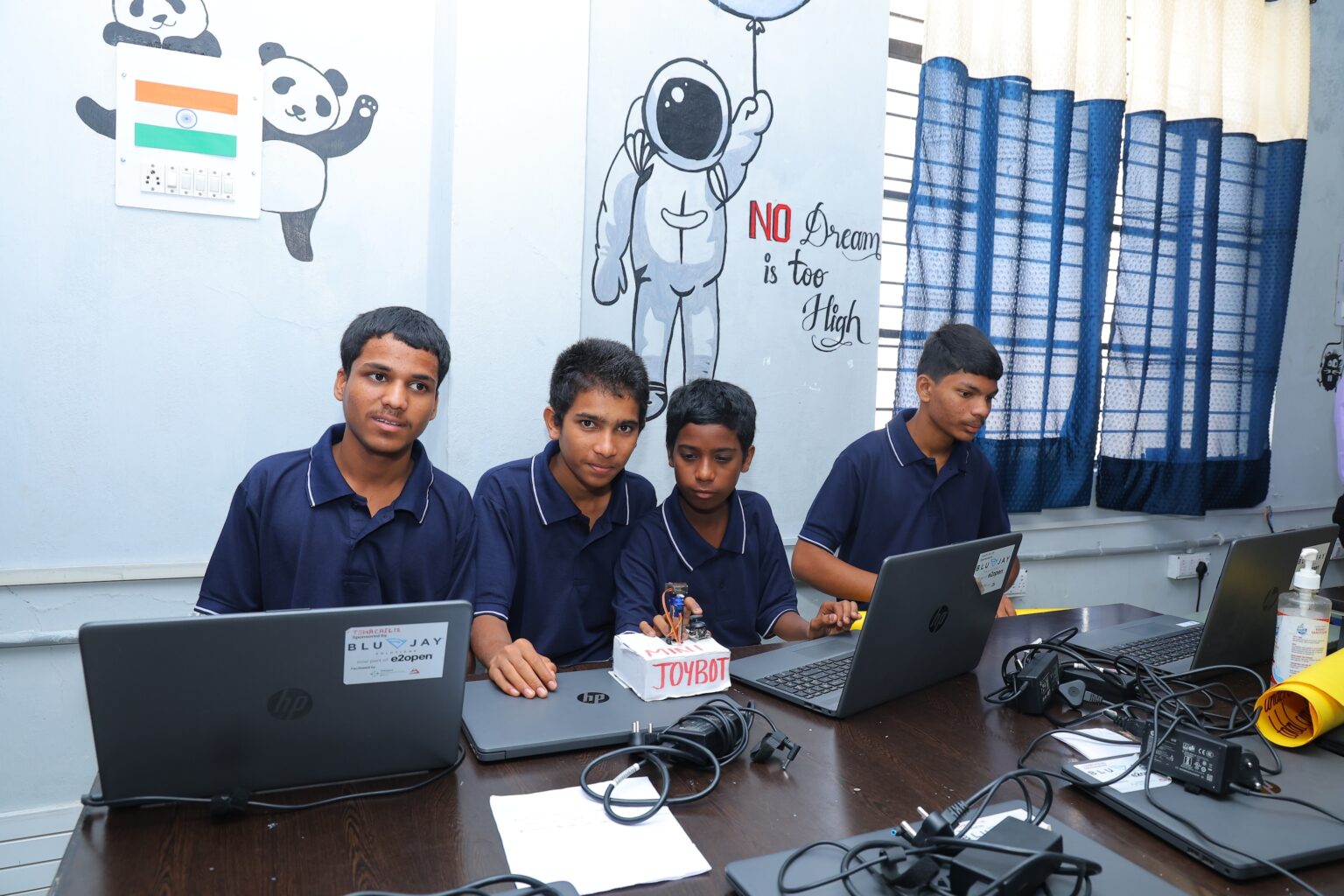 A group of male students working on a coding project.