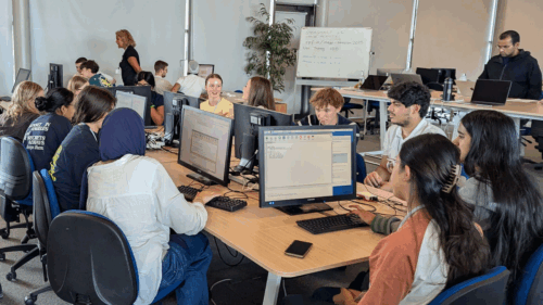 Photo of a class of students at computers, in a computer science classroom.