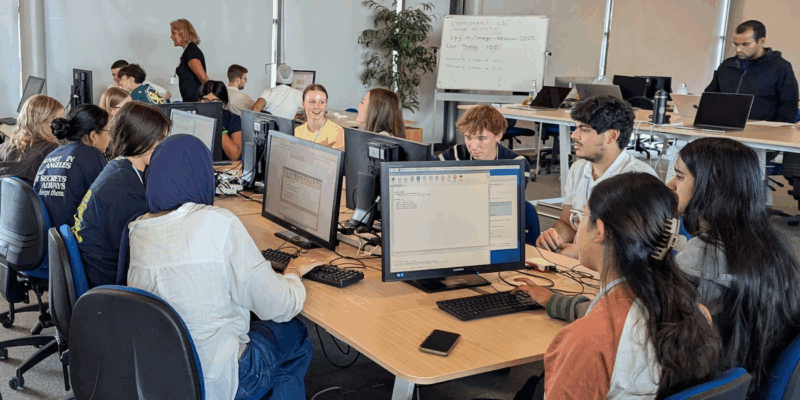 Photo of a class of students at computers, in a computer science classroom.