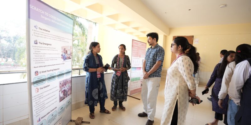 Teachers present a poster at the Computing and AI for All event.