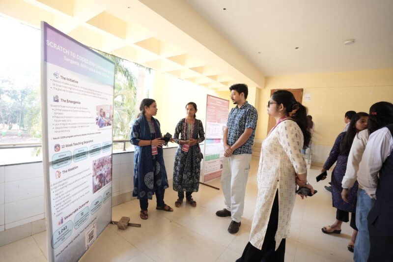 Teachers present a poster at the Computing and AI for All event.