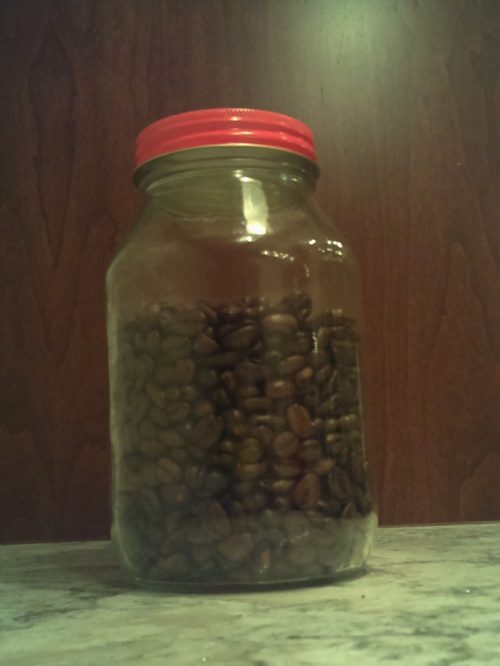 A jar which is almost full of coffee beans